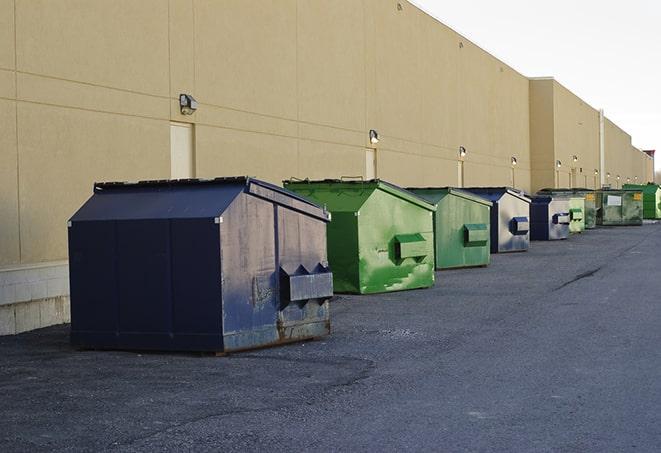 a series of colorful, utilitarian dumpsters deployed in a construction site in Brooklyn, NY